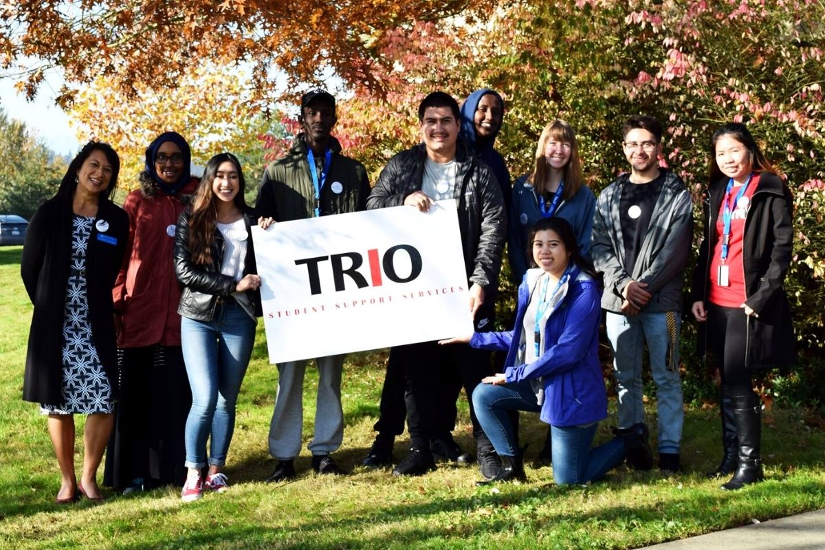 TRIO students posing surrounded by autumn foliage  