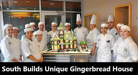 Pastry students pose next to gingerbread house 