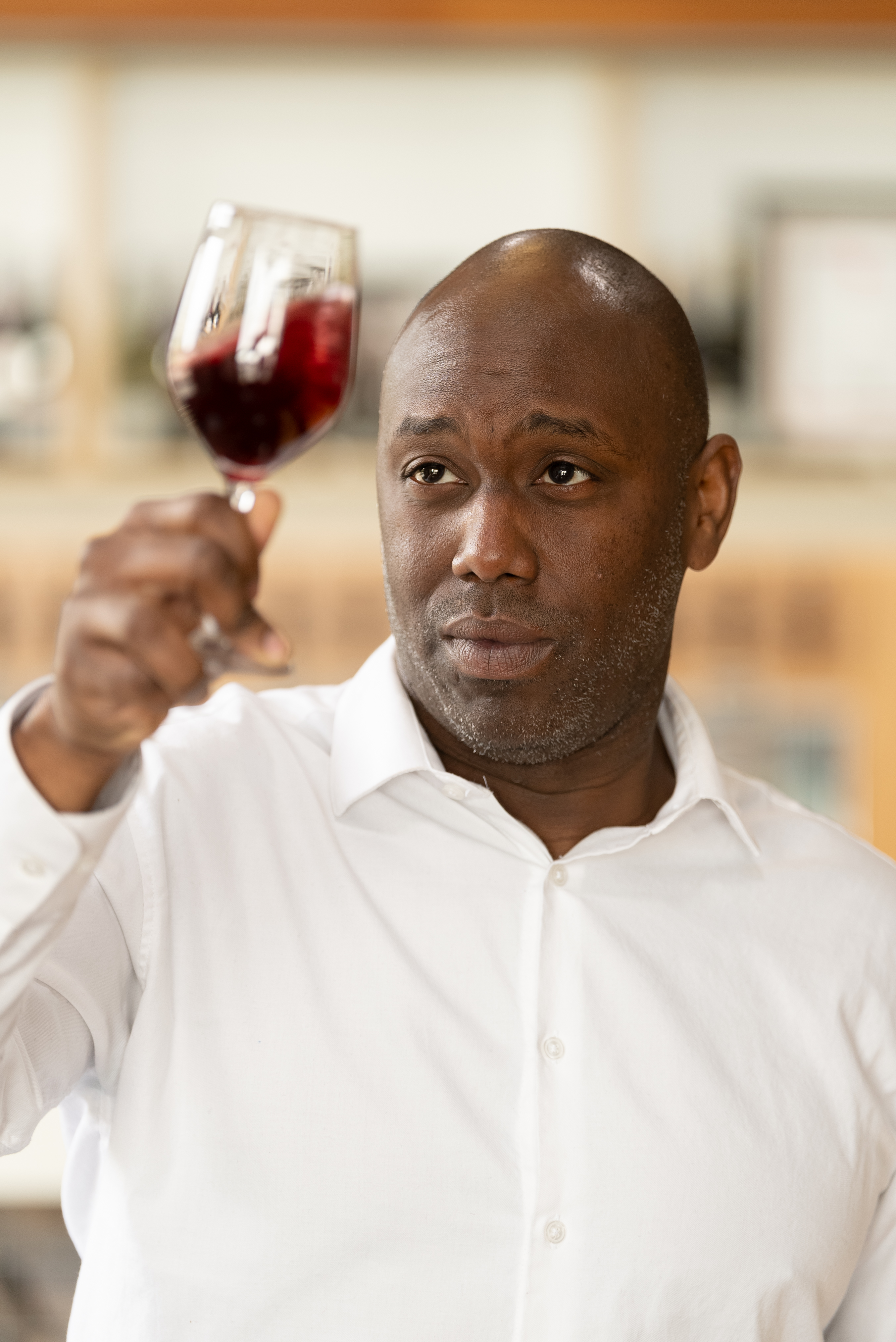 Jerome Price in the Northwest Wine Academy swirling a glass of wine.