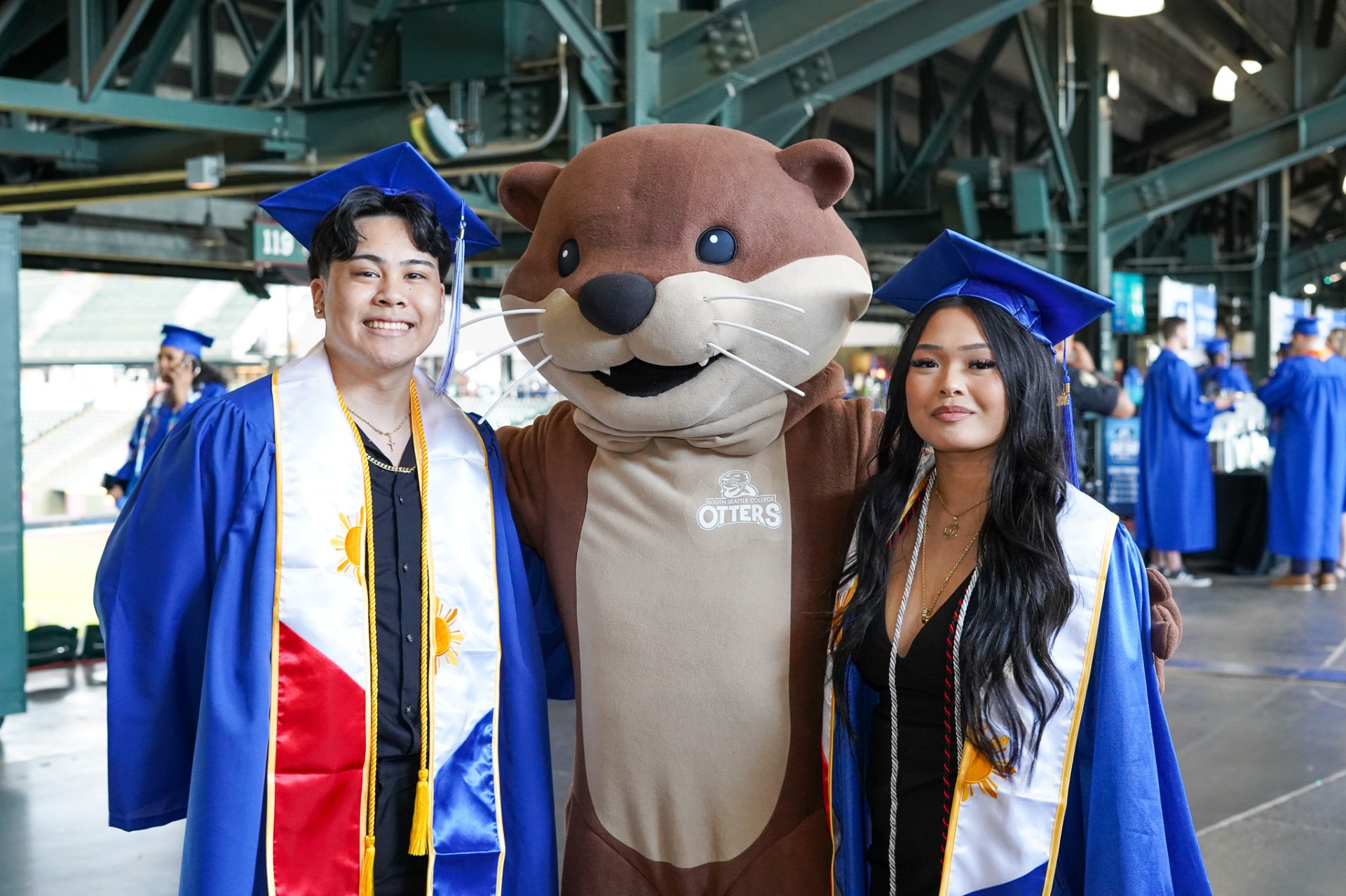 South Seattle College graduates pose with South's Otter Mascot at T-Mobile Park on June 21, 2024