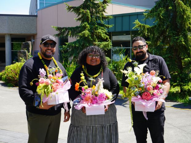 [L-R] Toka Valu, Eileen Jimenez and Scott Mexcal posing with floral arrangements they received from the mural class students