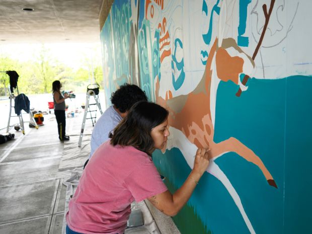 Community members helping paint the mural
