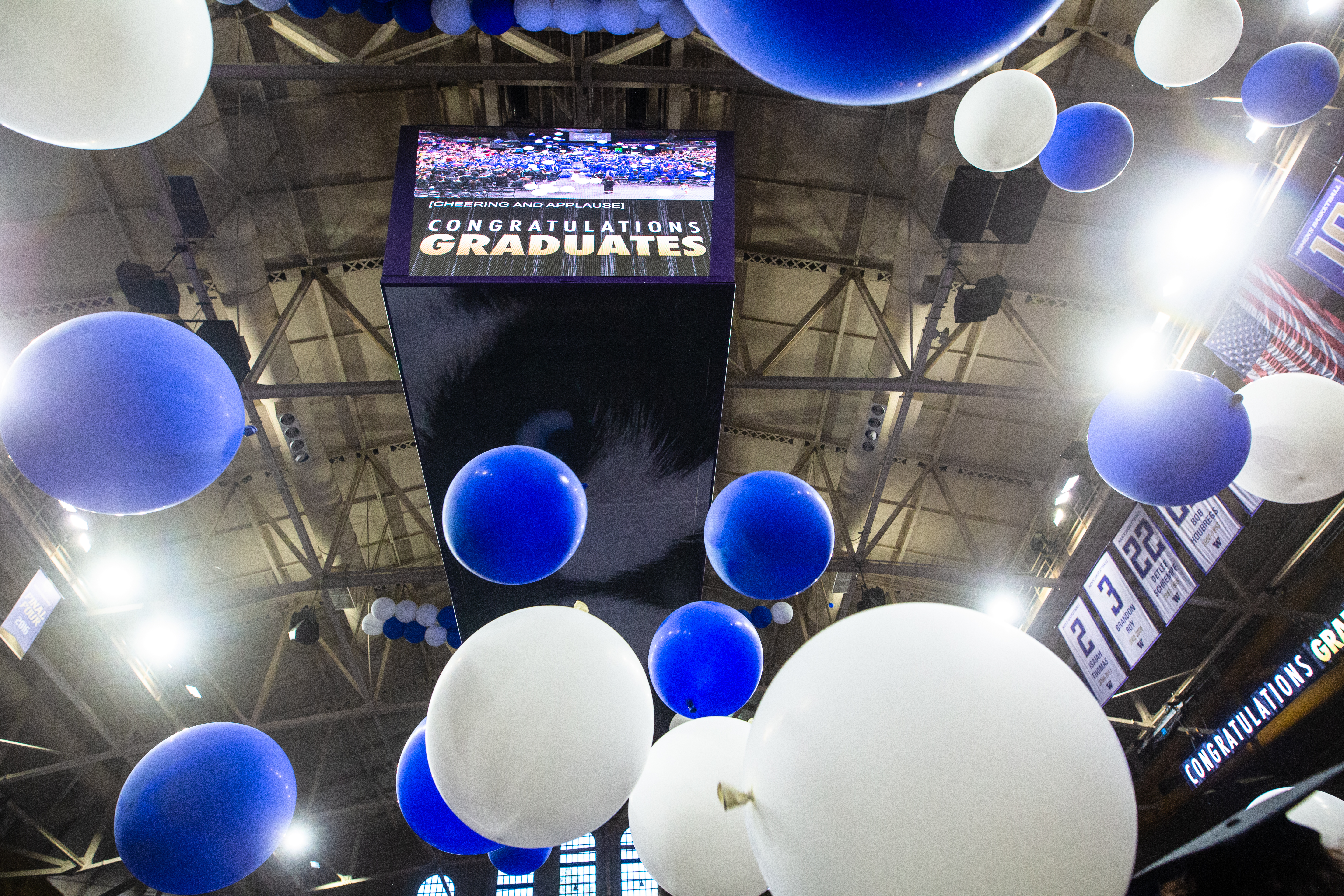 Balloons drop from the ceiling, surrounding a sign that says Congratulations Graduates at the 2026 Commencement Ceremony.  