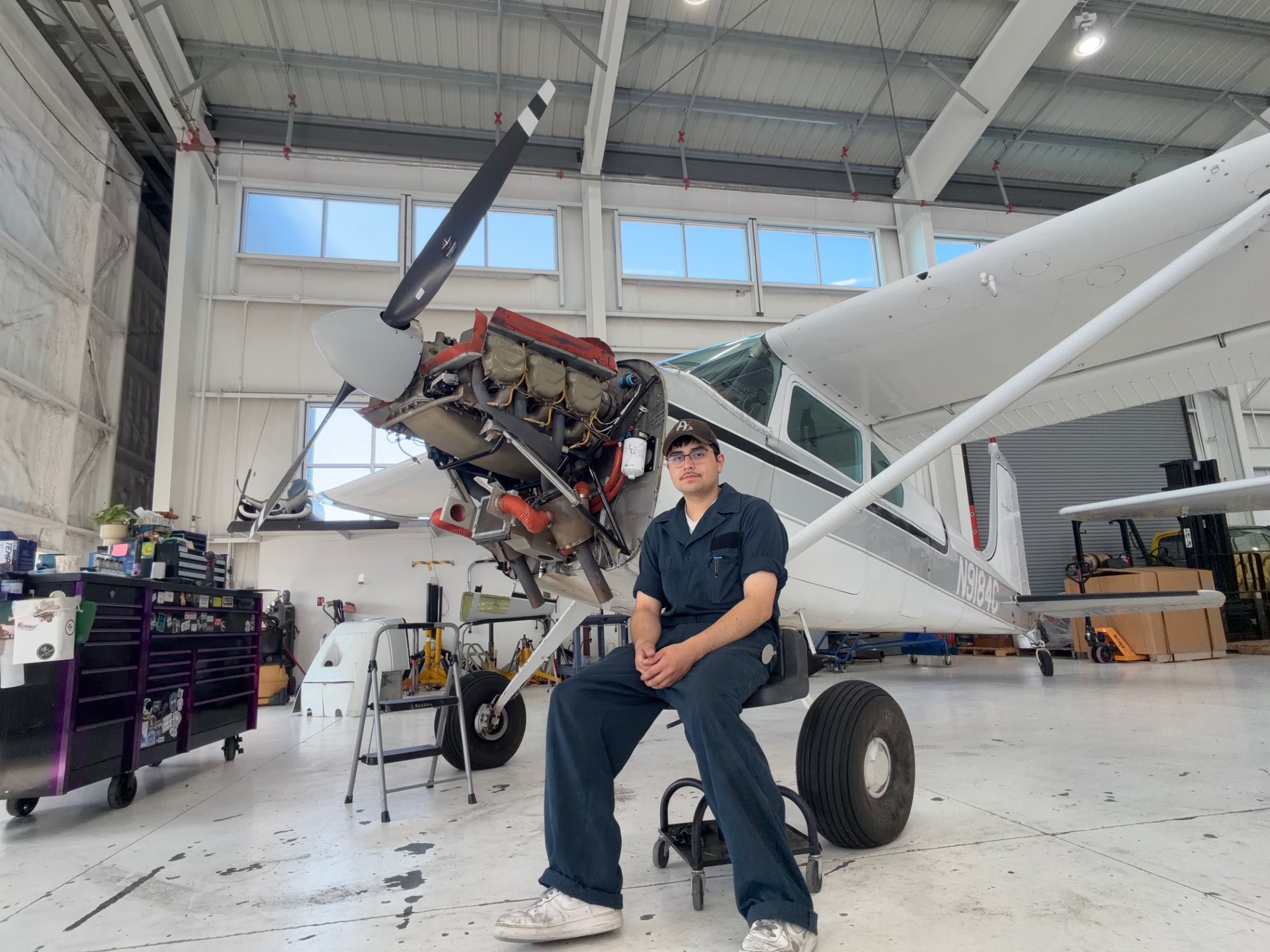 Student Jason Mercado in front of a plane